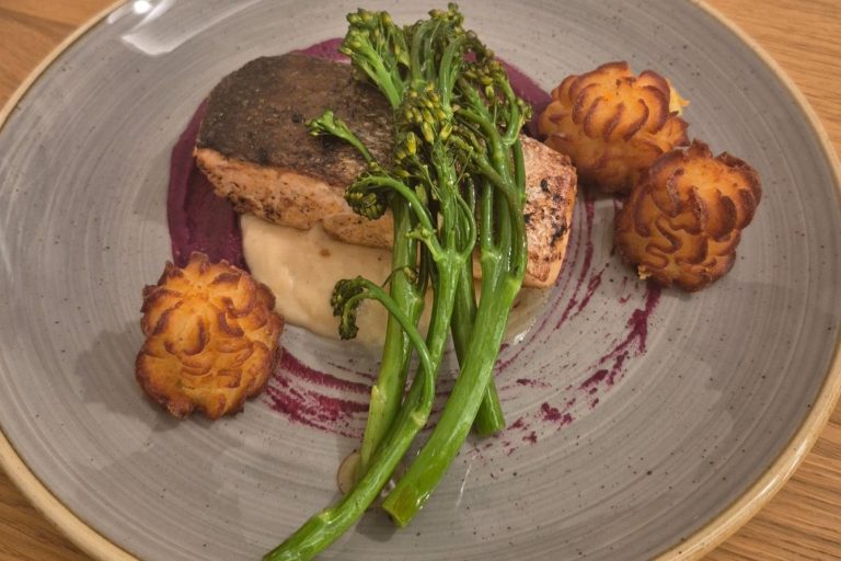 Elegante Gartentafel mit Blumen und festlicher Tischdekoration für eine Veranstaltung.